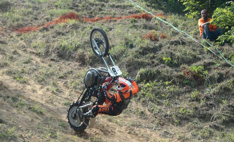Wade Schultz of Lisbon, Iowa, hangs on as he flips his motorcycle on one of his runs at the Rock River Riders Motorcycle Club's hillclimb on Sunday, Aug. 3, 2025. Schultz recovered to make other runs later in the day.