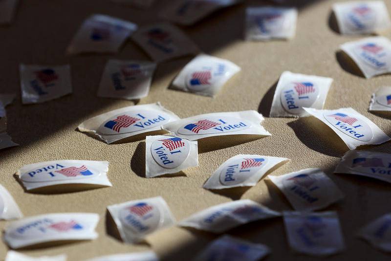 A pile of stickers reading "I Voted" bask in the morning sunlight in November 2020 at Main Beach in Crystal Lake.