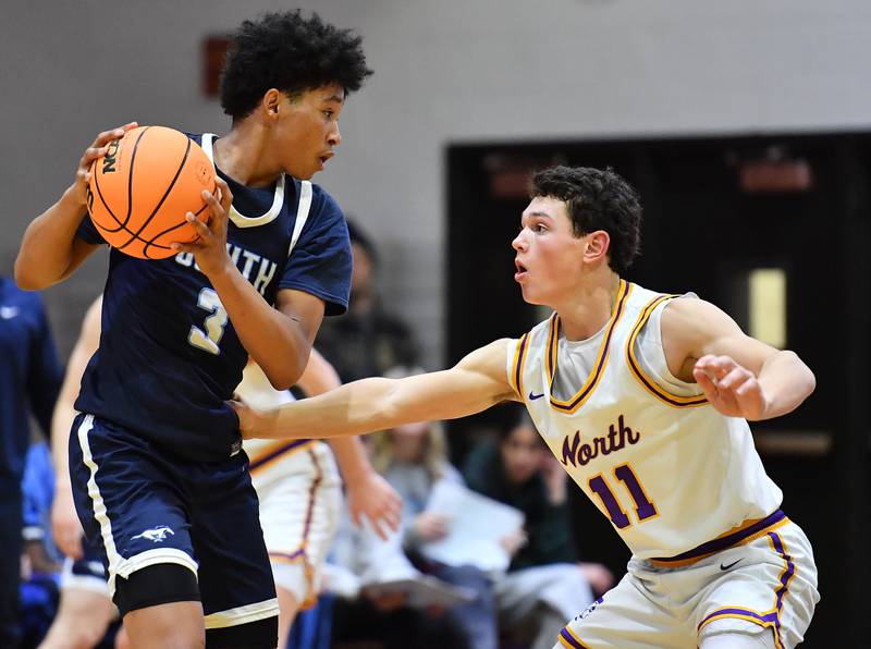Downers Grove South’s Adam Flowers (3) looks to pass as Downers Grove North’s Connor Crowley defends during a game on December 20, 2025 at Downers Grove North High School in Downers Grove.