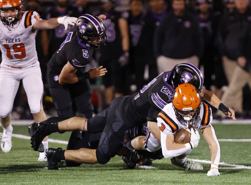 Wheaton Warrenville South's Owen York (3) is tackled by Downers Grove North's Antonio Kollintzas (22) during the 7A first-round playoff game between Wheaton Warrenville South and Downers Grove North high schools on Friday, Nov. 1, 2024 in Downers Grove.