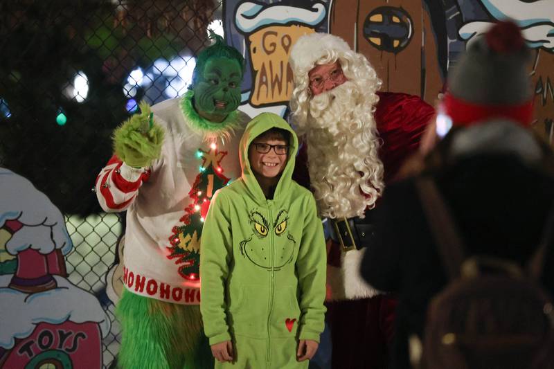 AJ Shirley, 10-years-old, gets his photo taken with the Grinch and Santa at Plainfield’s holiday kickoff Grinchmas on the Green on Saturday, Dec. 5, 2025 in Plainfield.