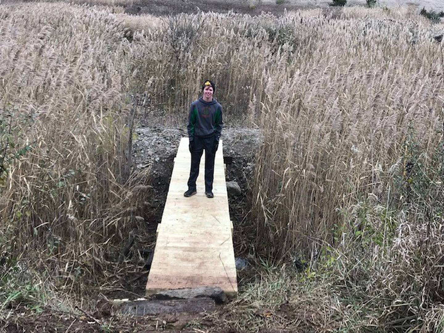 Cooper Vaske, 18, of Peru, stands on the finished bridge at the Rotary Park disc golf course in La Salle. He constructed the bridge at a cost of about $1,400, of all donated materials, for his Eagle Scout project.