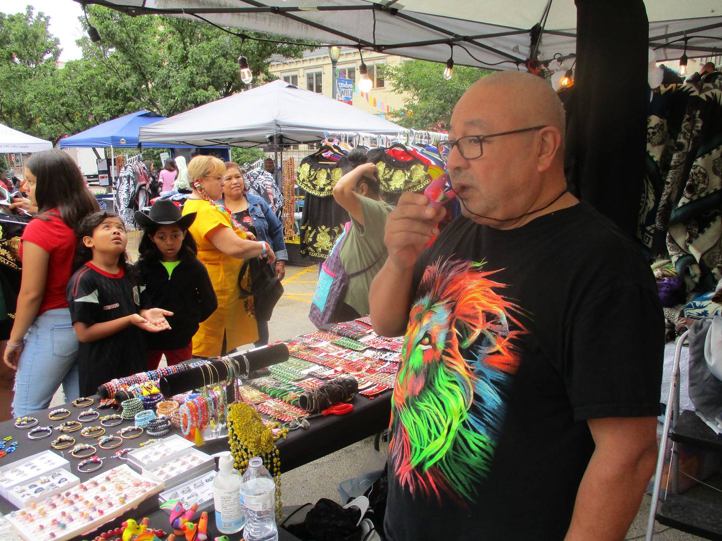 Salvador Sanchez demonstrates a bird-call whistle, which he said was a popular toy for Mexican children in his youth, during Fiesta en la Calle in Joliet on Saturday, Sept. 16, 2023.