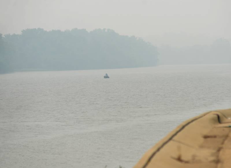 A boat is barely visible as it sits on the Rock River north of Oregon Tuesday morning. Smoke from wildfires in Canada is again drifting down to northern Illinois affecting air quality.