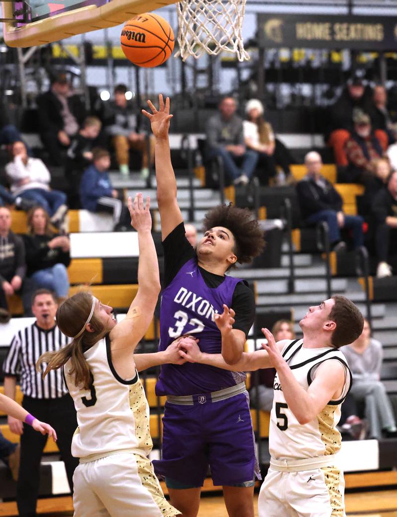 Dixon’s Darius Harrington shoots between Sycamore's Carter McCormick (right) and Preston Picolotti during their game Tuesday, Jan. 14, 2025, at Sycamore High School.