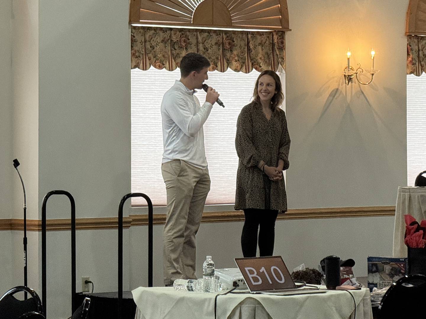 Sam Mateski (left), an intern with the City of Morris, addresses the crowd during bingo at the Senior Expo on Wednesday, May 21, 2025. To his right is Julie Wilkinson, the City of Morris's Business Development Director.