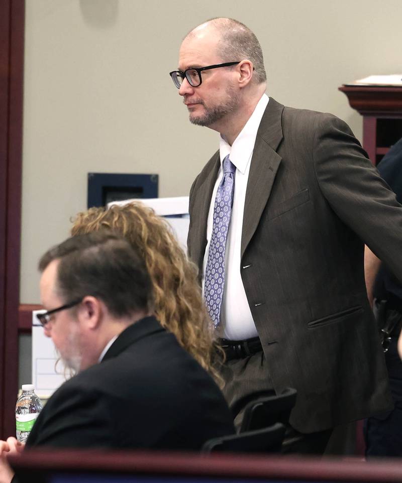 Jonathan Hurst takes his seat with his legal team after being brought over from the jail Thursday, Jan. 23, 2025, during his trial at the DeKalb County Courthouse in Sycamore. Hurst is charged in the 2016 slayings of Sycamore elderly mother and son Patricia and Robert Wilson.