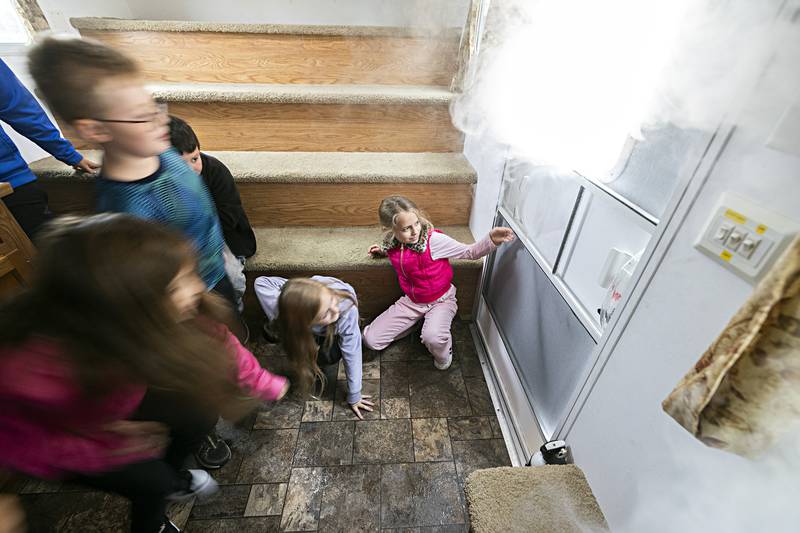 Jefferson School third grader Carly LaFevre tests the door in a fire safety house for heat during a drill Thursday, Oct. 12, 2023.