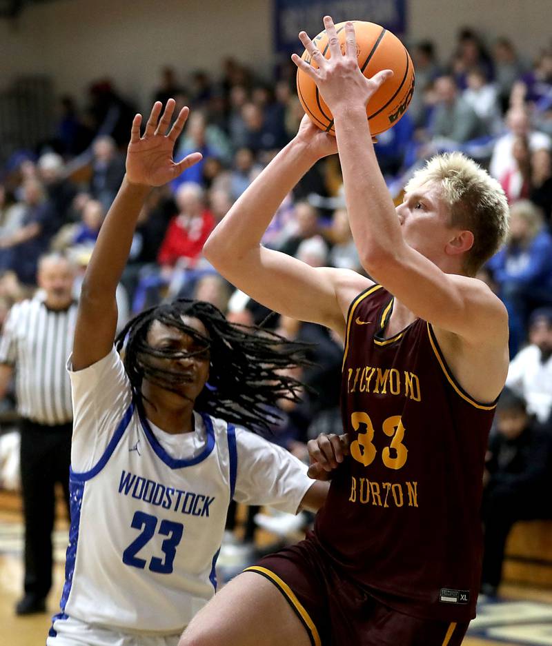 Richmond-Burton's Luke Robinson (right) drives to the basket against Woodstock's Marc Thomas during a Kishwaukee River Conference boys basketball game on Wednesday, February. 4, 2026, at Woodstock High School.