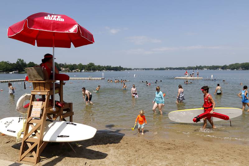 Lifeguards keep watch and people swim at Crystal Lake's Main Beach on Friday, June 21, 2024.