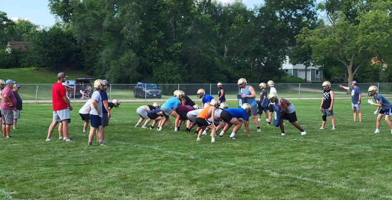 The Marquette football team works on offensive plays during football camp on Wednesday, July 17, 2024 on the practice field next to Gould Stadium in Ottawa.