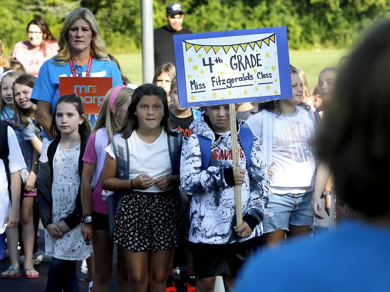 Children listen to Principal Beth Klinsky speak during the first day of school at West Elementary School in Crystal Lake on Wednesday, Aug. 16, 2023.