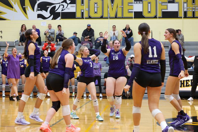 Wilmington's Melia Hincherick, center, turns to celebrate with teammates after winning the first set during the Wildcats' loss in three sets, 25-16, 22-25, 17-25, to Pontiac in the IHSA Class 2A Herscher Regional championship on Thursday, Oct. 30, 2025.