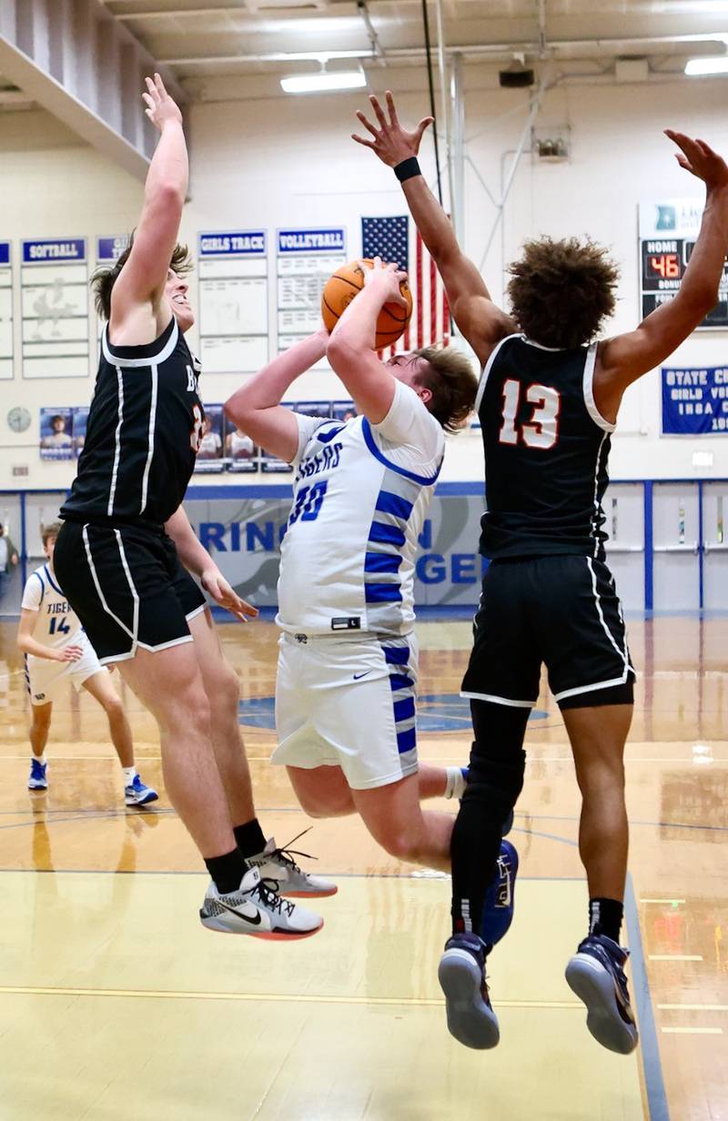 Princeton's Jordan Reinhardt drives against Byron's Caden Considine and JJ Edmonson Saturday night at Prouty Gym.