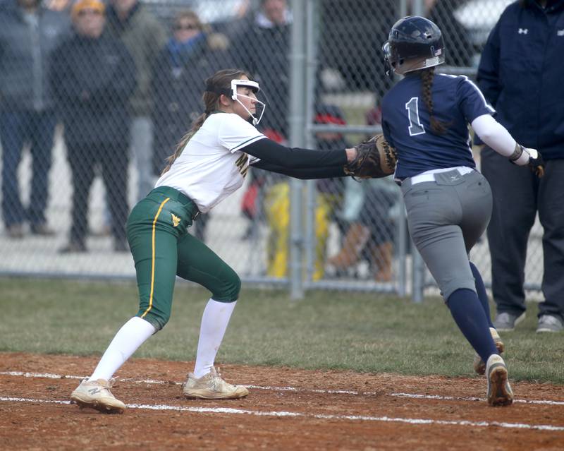 Waubonsie Valley first baseman Gia Cobert tags out Oswego East’s Gracie Vlach (1) during a game at Waubonsie Valley on Friday, April 1, 2022.