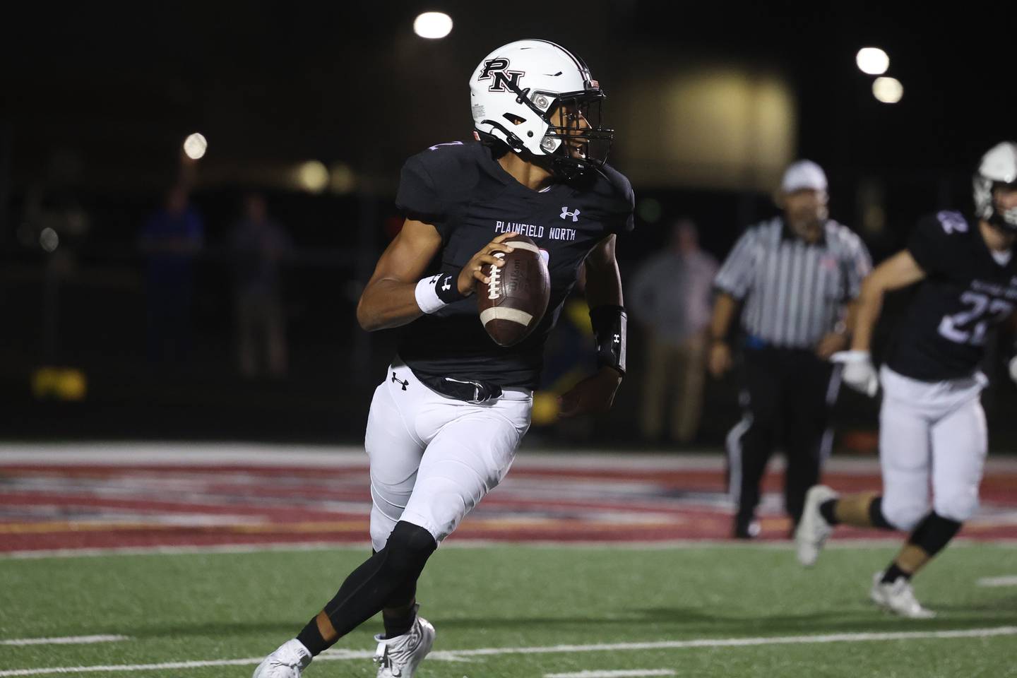 Plainfield North’s Demir Ashiru looks to pass against Lyons in round two of the Class 8A playoffs on Friday