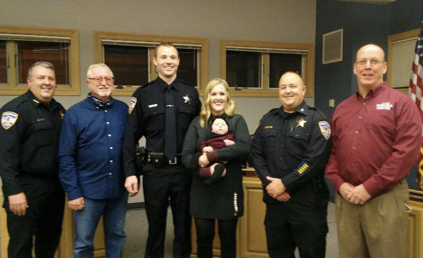 Pausing for a photo after the swearing-in ceremony of Yorkville police patrol Officer Tyler Lobdell are, from left, police Chief Jim Jensen, Yorkville Board of Fire and Police Commissioners Chairman Robert Johnson, Officer Lobdell, wife Mallory and baby Monroe, Deputy Chief Ray Mikolasek and Mayor John Purcell. (Mark Foster - mfoster@shawmediacom)
