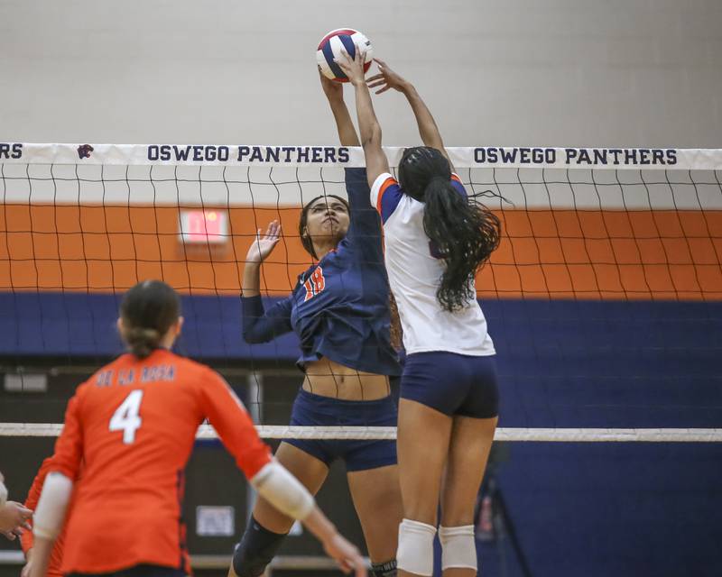 Oswego's Maya Norlin (18) meets Romeoville's Arianna Thomas (8) at the net during volleyball match between Romeoville at Oswego. Oct 16, 2025.