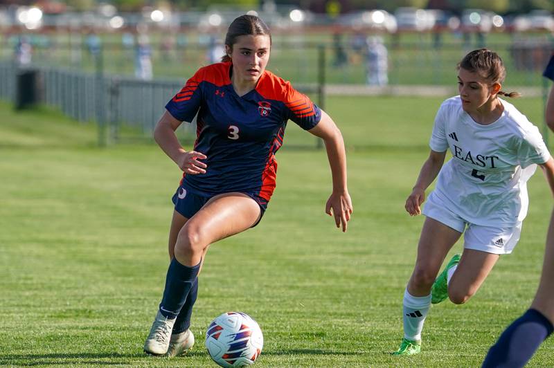 Oswego’s Mane Brolley (3) dibbles the ball up the field against Oswego East during a soccer match at Oswego High School on Tuesday, April 29, 2025.