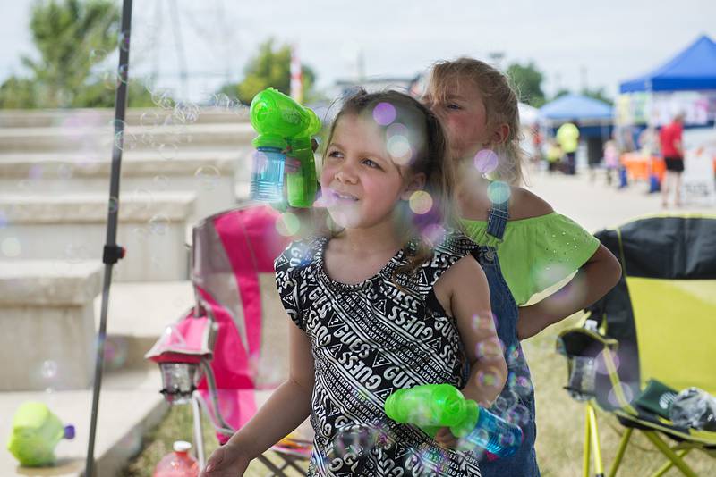 Helen Smith (left), 5, and Layla Davis, 5, have fun with some bubble guns Friday at Rock Falls’ Summer Splash. The fun will continue on Saturday from 11 a.m. to 3 p.m.