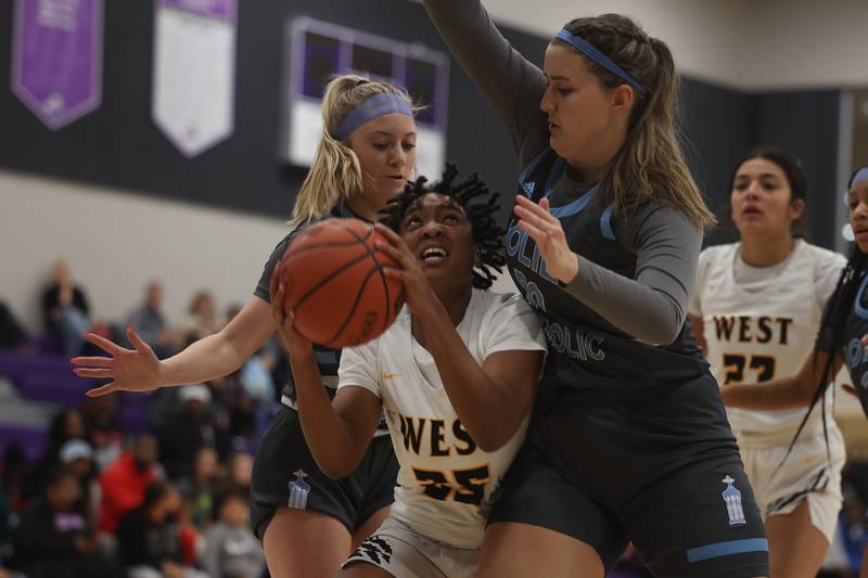Joliet West’s Mariah Shelton battle in the paint for a shot against Joliet Catholic in the WJOL Basketball Tournament at Joliet Junior College Event Center on Monday