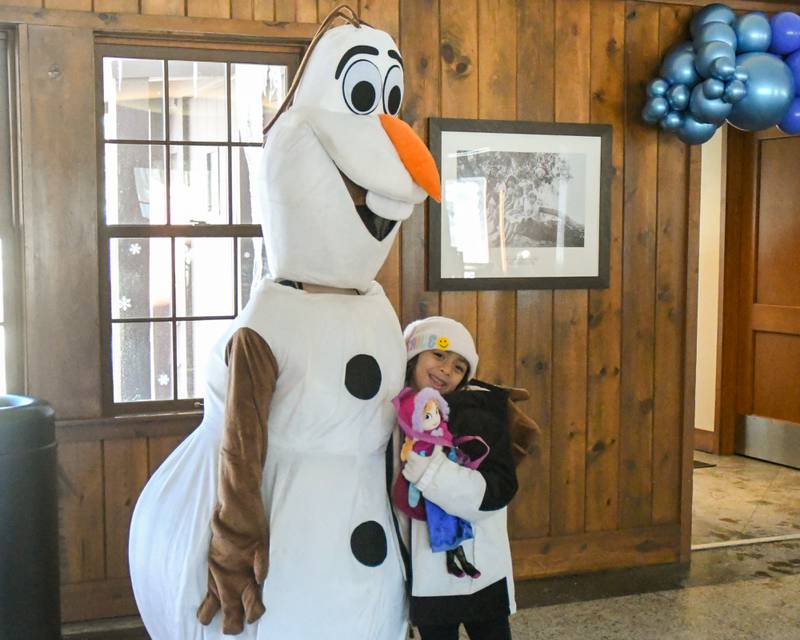 Camila Saucedo, 6, of Glen Ellyn is all smiles while taking a photo with Olaf from Frozen during the Frozen Fest event held at Lake Ellyn in Glen Ellyn on Saturday Jan. 20, 2024.
