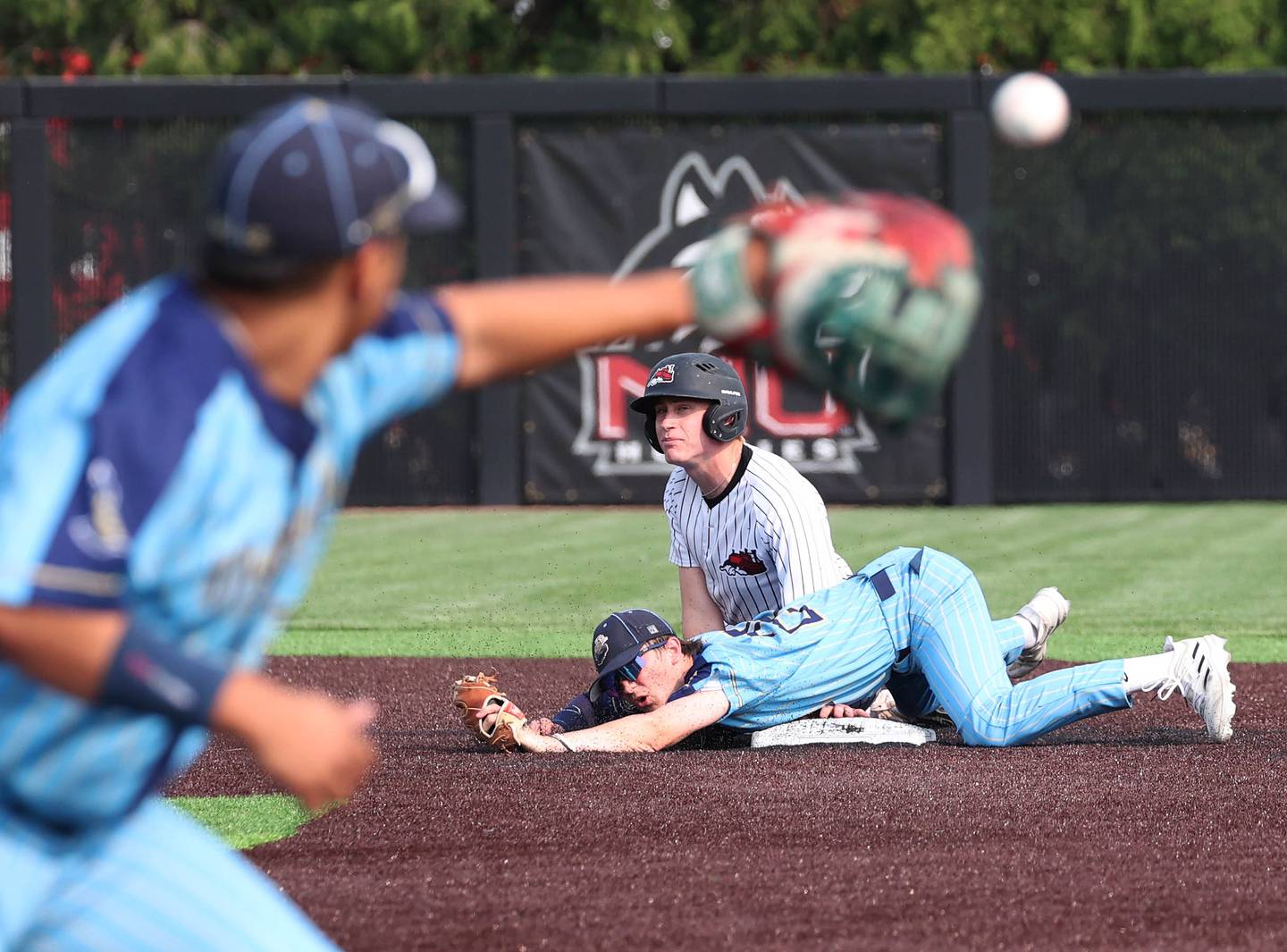 Marquette's Griffin Dobberstein (bottom) and Fulton's Jacob Huisenga watch to see the call at first after Dobberstein forced out Huisenga on the double play attempt Monday, June 2, 2025, during their Class 1A supersectional game at Northern Illinois University in DeKalb.