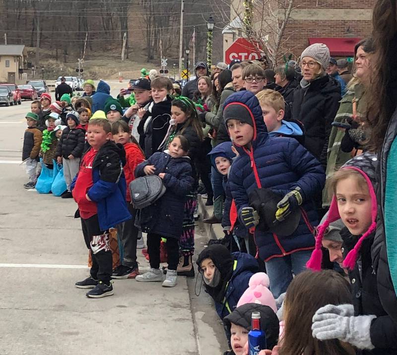 Kids watch as the St. Patrick's Day parade starts coming down the street on Saturday, March 11 in downtown Utica.