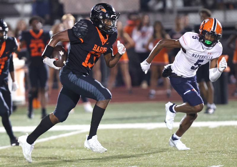 DeKalb’s Davon Grant carries the ball after a catch with Naperville North's Luke Williams in pursuit during their game Friday, Sept. 22, 2023, at DeKalb High School.