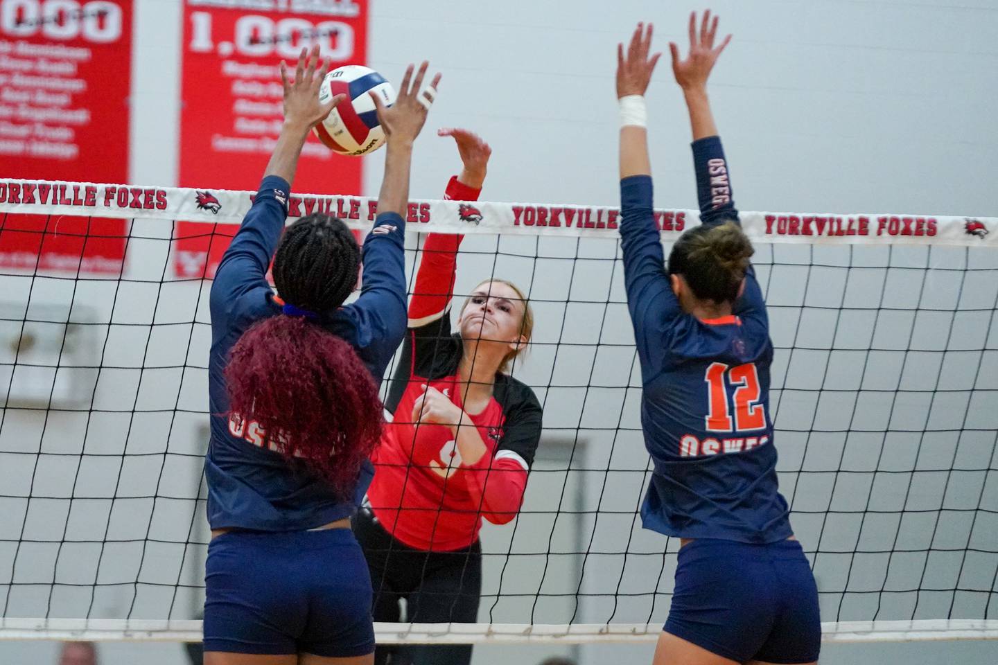 Yorkville's Lilianna Casbarian (9) goes up for a kill attempt against Oswego’s Maya Norlin (18) and Ava Flanigan (12) during the Class 4A Yorkville Regional final at Yorkville High School on Thursday, Oct. 31, 2024.