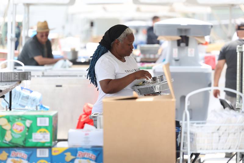 Flora Jones, a franchise own of Popus Gourmet Popcorn, sets up her tent for the Taste of Joliet on Thursday, June 22, 2023.