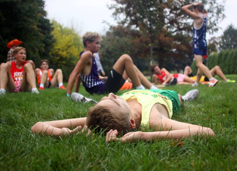 Boys runners rest after concluding the Fox Valley Conference Cross Country Meet at McHenry County College in Crystal Lake on Saturday, October. 18, 2025.