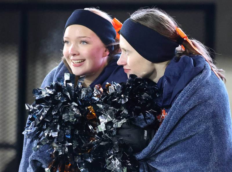 Members of the Oswego dance team try to stay warm Wednesday, Dec. 3, 2025, during the IHSA Class 8A state chamionship game in Huskie Stadium at Northern Illinois University in DeKalb.