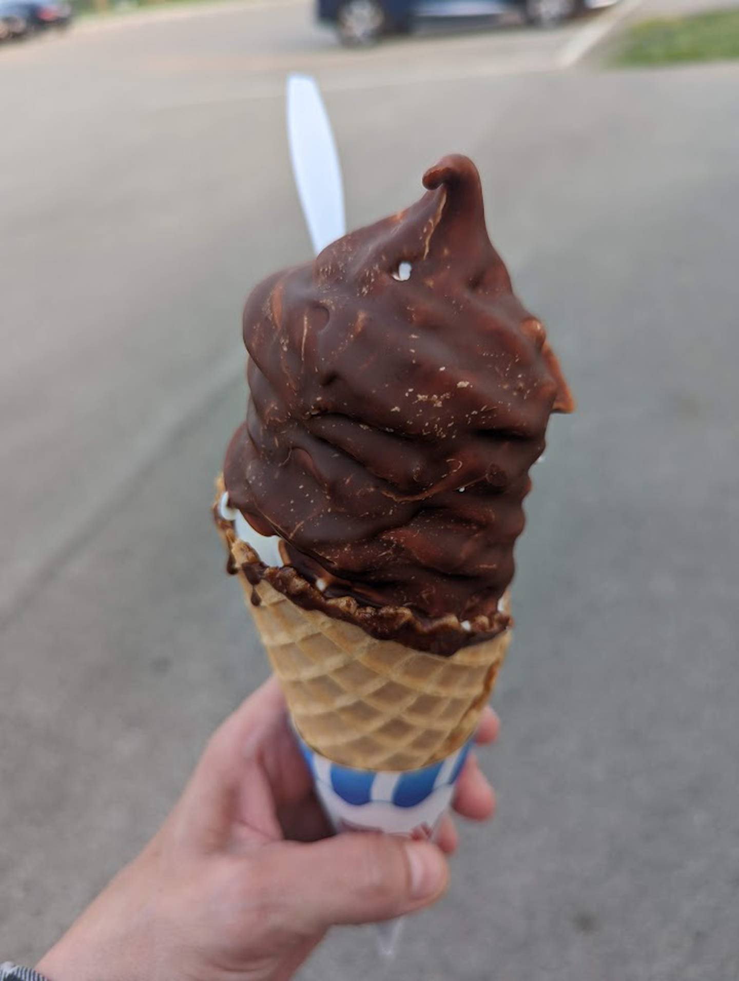 Pictured is a soft serve vanilla ice cream in a waffle cone and with a chocolate topping as served at the Minooka Creamery,