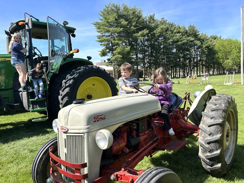 Memphis Mongan encouraged her pre-kindergarten classmate, Kyland Mockavack, to hop on the vintage Ford tractor to go for a "ride" during Oregon High School's FFA agriculture event on Friday, May 9, 2025, FFA kids brought their tractors to the Oregon Elementary School for grade school students to explore. A petting zoo with a variety of animals cared for by FFA students was also part of the event.