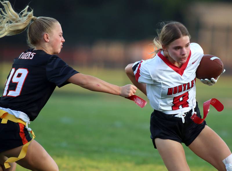 Huntley’s Addison Avi, right, runs the ball as Crystal Lake Central’s Mae Anderson, left, grabs her flag in varsity flag football at Owen Metcalf Field on the campus of Crystal Lake Central High School in Crystal Lake on Tuesday, Sept. 16, 2025.