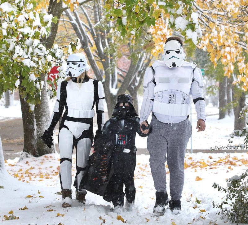 Sarah Moore, (left) her husband Matt and his son Cooper, 6, of DeKalb, dressed as Stormtroopers and Darth Vader to trudge through the snow on Margaret Lane to go trick-or-treating Thursday. Snow and cold made it difficult for those that ventured out on Halloween.