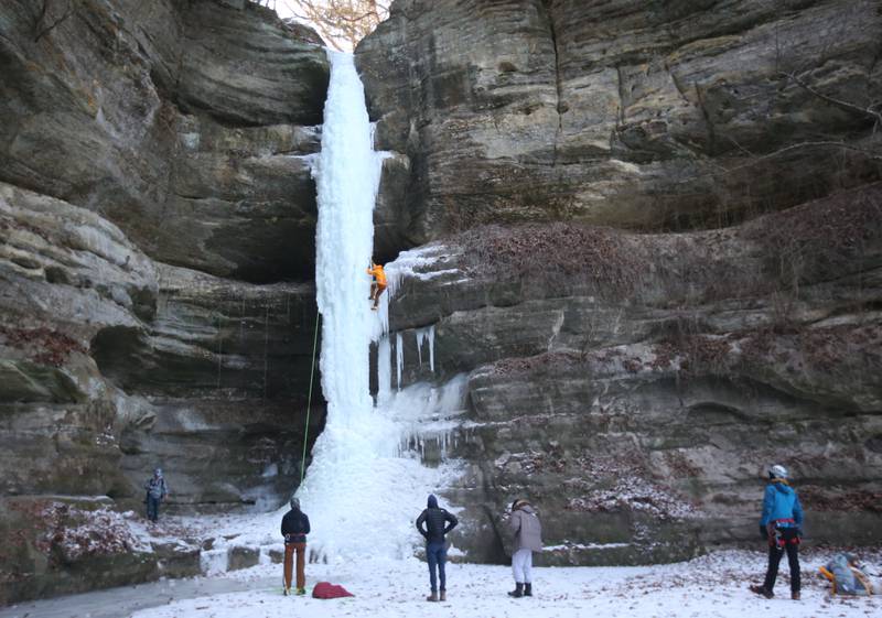 Gerry Voelliger of Bettendorf, Iowa, (top) climbs up a 80-foot frozen waterfall inside Wildcat Canyon on Friday, Jan. 24, 2025, at Starved Rock State Park.