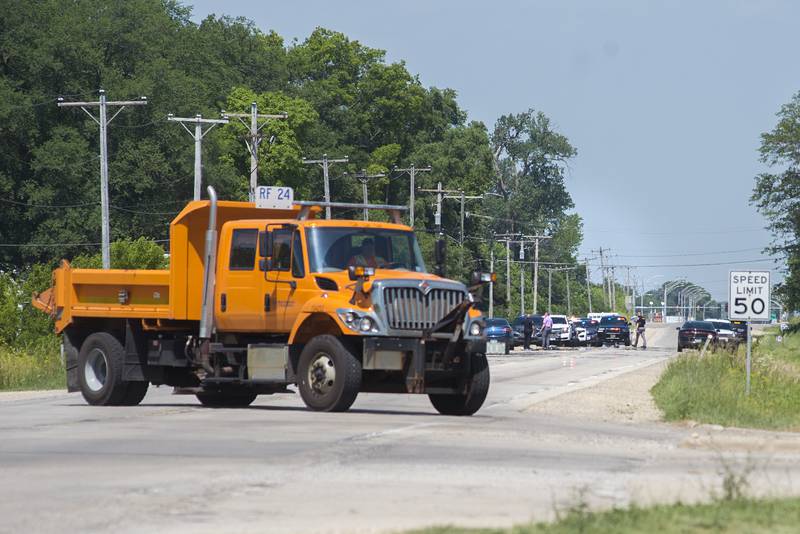 State, local and Whiteside County police work at the scene of a crash on east Route 30 in Rock Falls on Tuesday. A vehicle that contained four people rolled over. The four fled the scene but were later taken into custody. An Illinois Department of Transportation truck is used to block off the street.