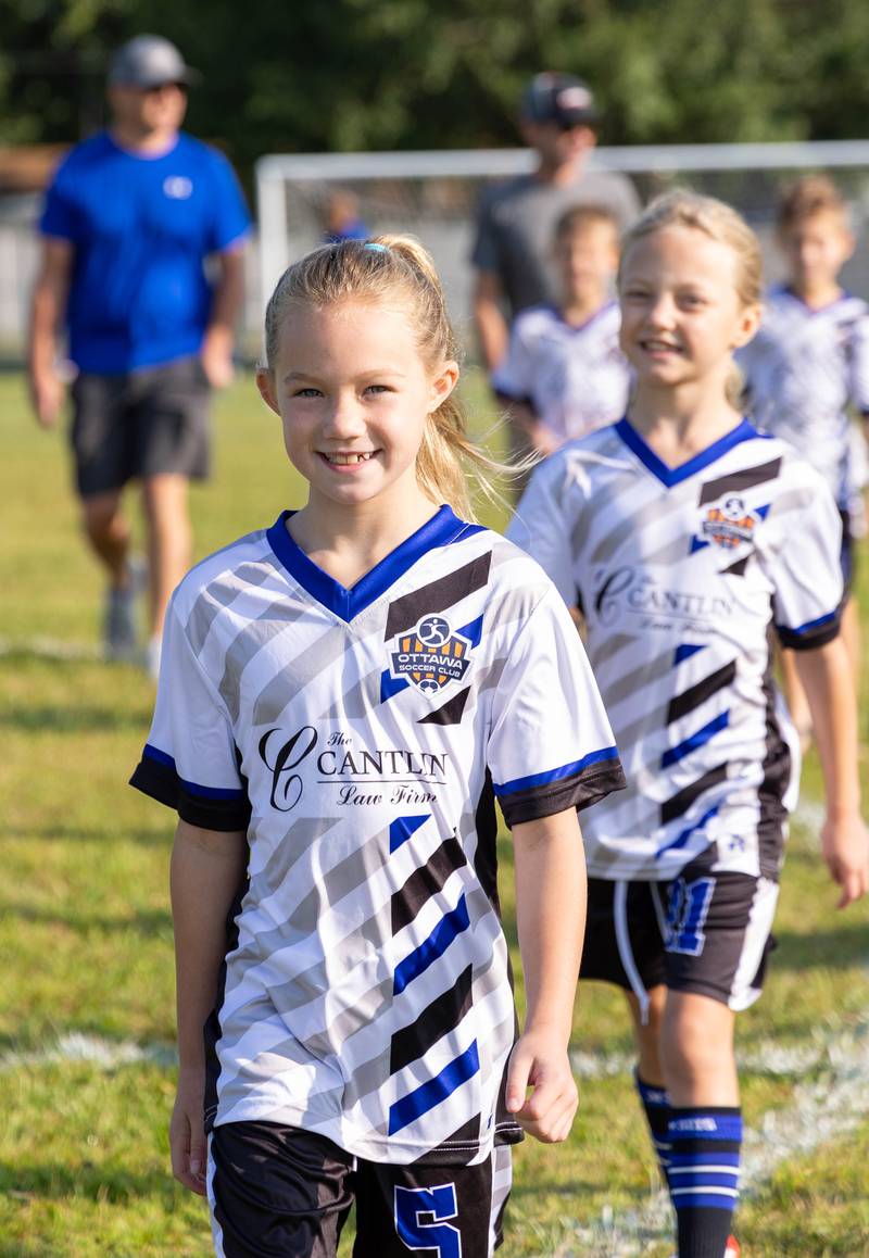 Players and coaches parade across the field Saturday, Aug. 19, 2023, during Ottawa Soccer Club's opening day.