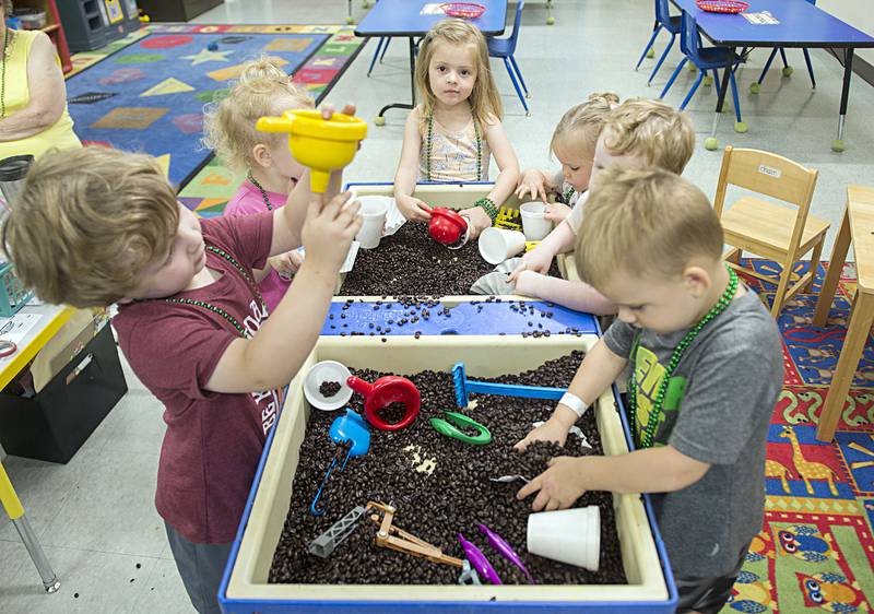 Dixon Family Y daycare kids play with coffee beans brought in by Starbucks for a morning of fun and crafts Tuesday, July 19, 2022.