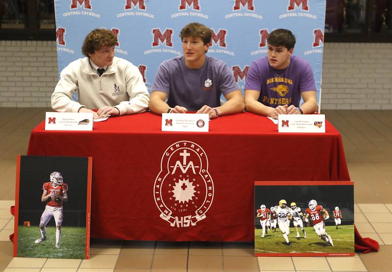 Marian Central football players Rylan Dolter, Christian Bentancur, and Cale McThenia talk before they sign their National Letter of Intent to attend and play football at the University of Montevallo, Clemson University, and the University of Northern Iowa on Wednesday, Dec. 20, 2023, at the high school in Woodstock.