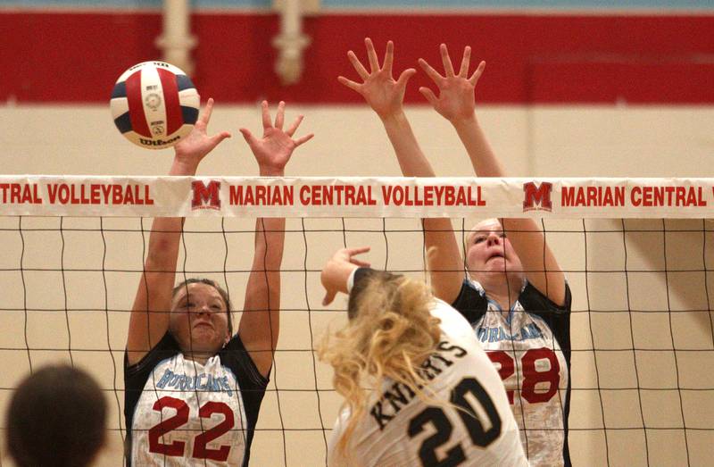 Marian Central’s Anna Lingle, left, and Nola Midday, right, block against Grayslake North in girls volleyball in Woodstock Monday.