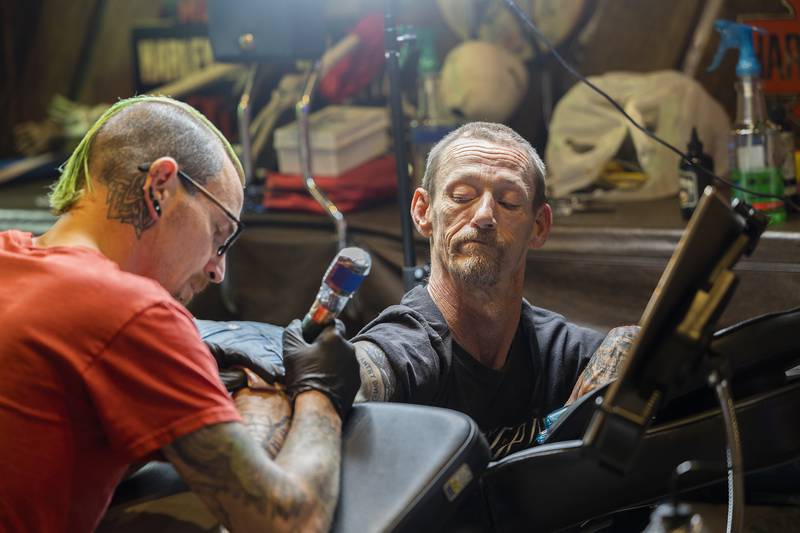 Clint Renner gets some new ink by Ink Storm Rebel owner Michael Baker Friday, June 27, 2025, at Herbal Root’s CannaFest. Music, bud, art and tattoos were just a few things on tap for the third annual event.