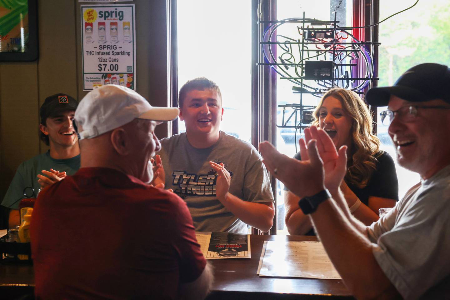 Tyler Shoven, center, reacts as he is surprised with a trip to the Super Bowl by Make-A-Wish Illinois volunteers last week as his family dined at Sammy's in Bourbonnais.