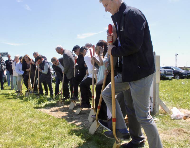 A host of assembled dignitaries join hotel developer Al Hill, who is center wearing a hat, during a groundbreaking ceremony on Wednesday, May 3, 2023, at the site for a Tru by Hilton near South Galena Avenue in Dixon.