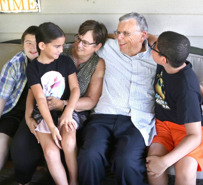 DeKalb County Sheriff Roger Scott and his wife, Marcia enjoy a moment with three of their ten kids David, (left) 15, Evalina, 7, and Ashton, (right) 11, in their DeKalb home Tuesday. Through the years the Scott's have adopted seven children and fostered over 40.