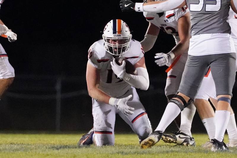 Oswego’s Trent Wollwert-Angle (19) recovers a fumble against Oswego East during a football game at Oswego East High School on Friday, October 25, 2024.