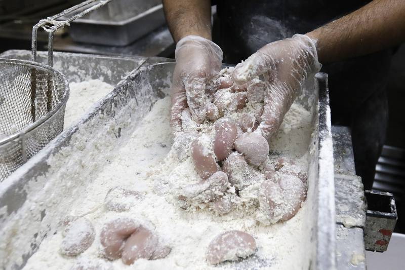 Parkside Pub cook Alfredo Andrado prepares a handful of turkey testicles coated in flour prior to deep frying with head cook Javy Garcia during the 39th annual Turkey Testicle Festival at Parkside Pub on Wednesday, Nov. 24, 2021, in Huntley.