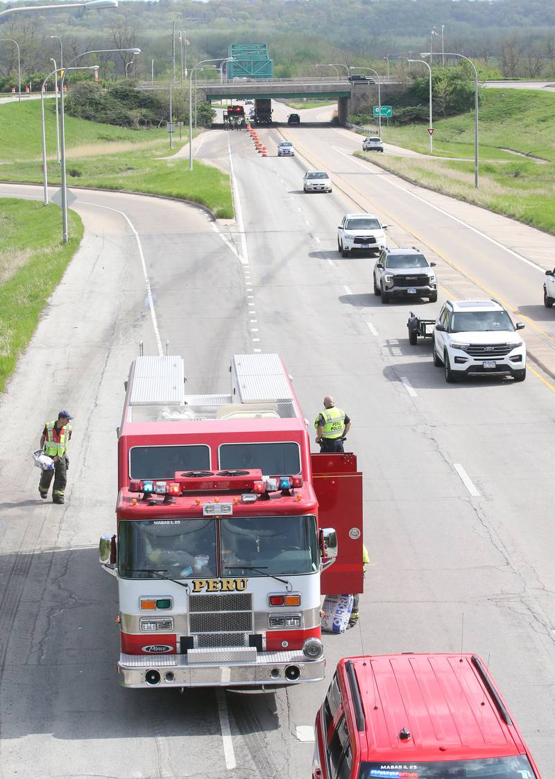Peru firefighters work the scene of a tractor and tandem disk that leaked hydraulic fluid on the shoulder of Illinois Route 251 and 7th Street overpass on Monday, April 28, 2025. Peru Fire, Illinois Department of Transportation and Peru police responded to the incident.